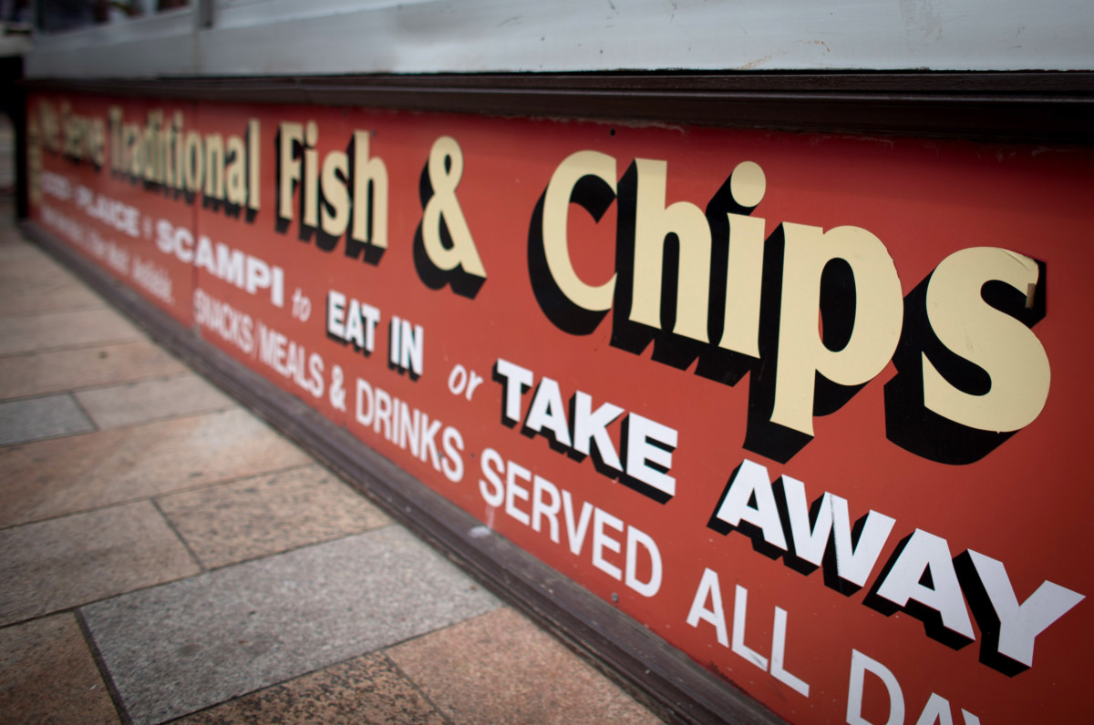 WESTON-SUPER-MARE, ENGLAND - JUNE 11: A sign outside a cafe advertises traditional fish and chips as people enjoy the fine weather on June 11, 2015 in Weston-Super-Mare, England. Many traditional British seaside resorts are gearing up for the summer season and will be hoping that the traditional attractions offered will help keep visitor numbers up. (Photo by Matt Cardy/Getty Images)